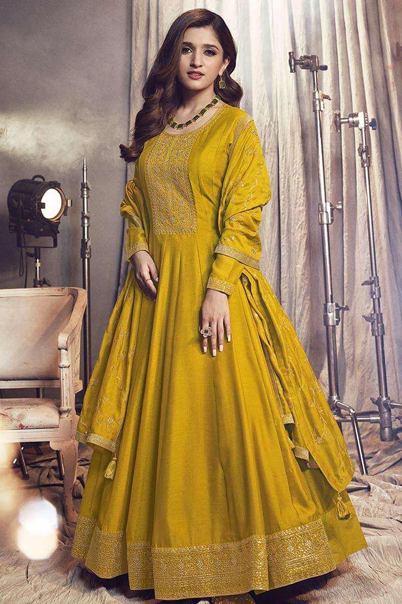 A mustard yellow gown in georgette jaquard fabric with the hand embroidery  detail in the neckline paired with a netted dupatta. - Tankhi Designs